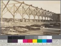 Sorting table of Caspar Lumber Company. Note monorail trolley for handling packages of lumber, and note also two-high piles of lumber. Upper pile is on level with sorting table floor and lower pile is below it on ground level. Caspar, California. May, 1920. E. F