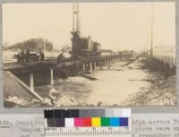 Repairing the Southern Pacific bridge across Tujunga Canyon where two of the concrete piers were washed out. The highway at the right on creosoted piles allowed greater space for exit of the water and was not washed out. March 1938. Metcalf