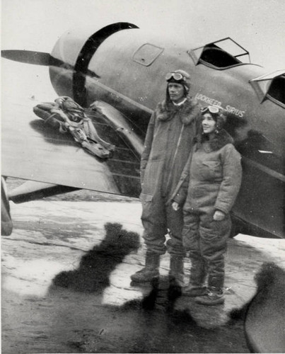 Charles Lindbergh and Anne Morrow Lindbergh in heated flight suits beside their Lockheed Sirius, Glendale, 1930