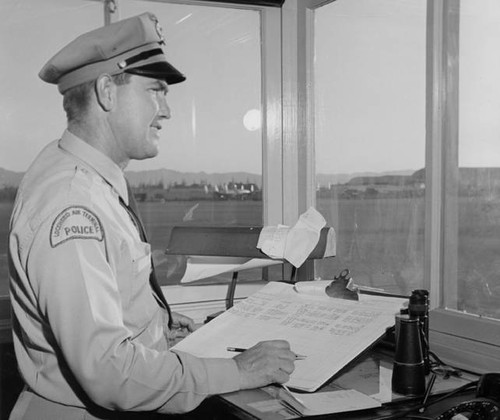 Lockheed Air Terminal Police officer Bill Andre in the Field Operations Office, Lockheed Air Terminal, Burbank, 1953