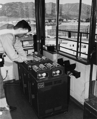 Lockheed Air Terminal, Lockheed Air Terminal Control Tower, Tape Recorder System. Interior view and view of runways, buildings, planes and mountains