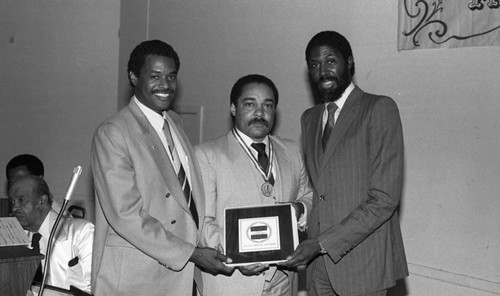 Mickey Cureton holding a plaque, Los Angeles, ca 1985