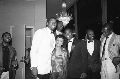 Magic Johnson posing with Gertrude Gipson and others at his birthday party, Los Angeles, 1985