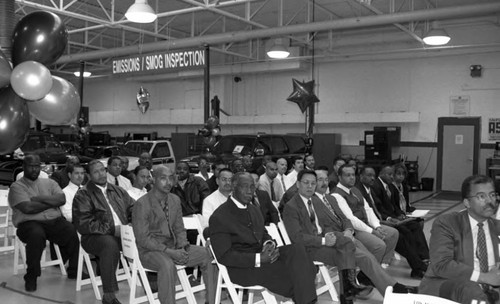 Men listening to a speaker during an Urban League Automotive Training Center graduation ceremony, Los Angeles, 1998