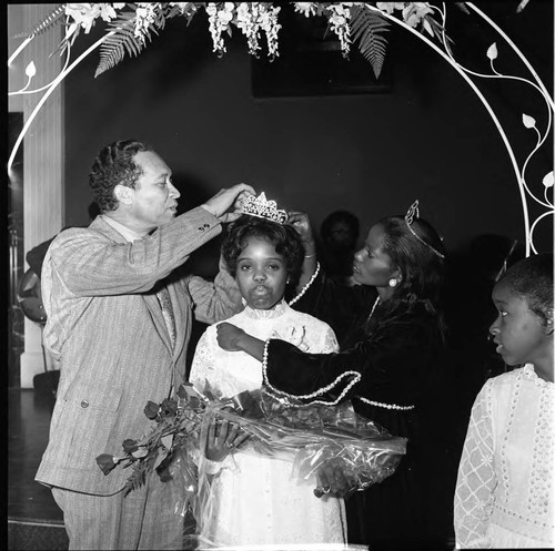 Compton Mayor Douglas Dollarhide placing a crown on a young girl, Compton, California, 1972