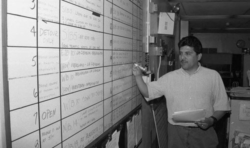 Man writing traffic updates on a whiteboard, Los Angeles, 1994