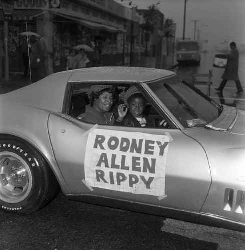 Rodney Allen Rippy waving from a Corvette during the Compton Christmas Parade, Compton, 1973