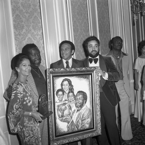 Clarence and Jacqueline Avant, Andrew Young, and Danny Bakewell posing with a portrait, Los Angeles, 1978