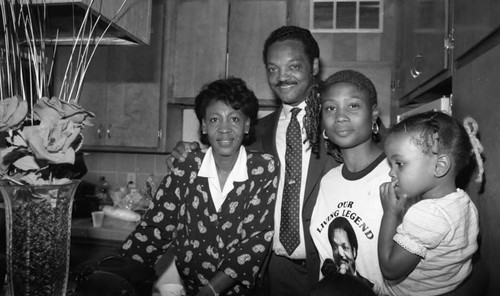 Rev. Jesse Jackson and Maxine Waters posing with a mother and child, Los Angeles, 1988