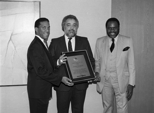 Danny Bakewell and others posing with a plaque, Los Angeles, 1987