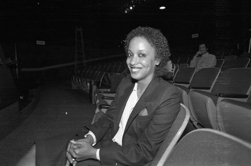 Unidentified woman sitting in a audience at Compton College, Compton, 1983