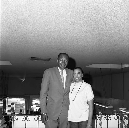 Tom Bradley posing with an unidentified woman in his campaign office, Los Angeles, 1969