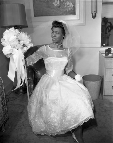 Lois C. Williams examining her bridal bouquet, Los Angeles, 1962