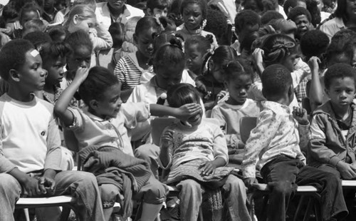 Watts Elementary school children watching a ceremony to change their school's name to Lovelia P. Flournoy, Los Angeles, 1982