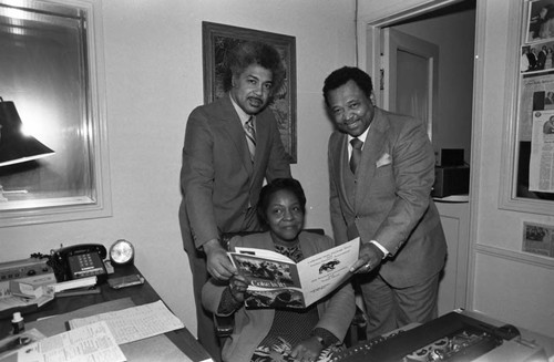 Bill Schultz, Marva Martin, and Jim Williams posing with a Cal-Pac conference program