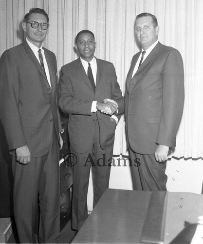 Three men inside office, Los Angeles, 1964