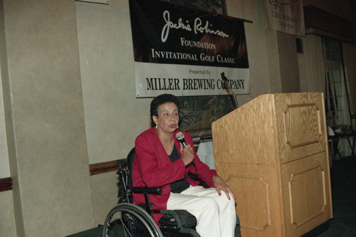 Woman speaking from a wheelchair at the Jackie Robinson Foundation Golf Classic awards dinner, Los Angeles