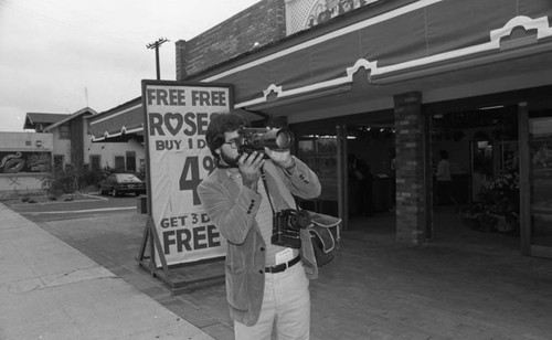 Photographer taking a picture at the opening of a Conroy's Flowers franchise., Los Angeles, 1982