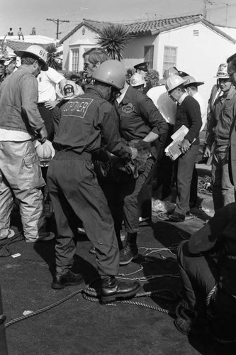 First responders and coroners at the scene of a sewer explosion and flash fire, Los Angeles, 1972