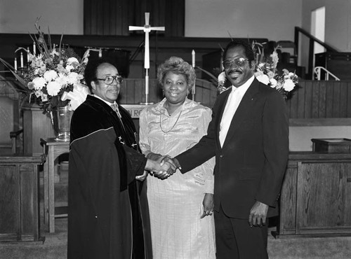 Rev. V. L. Brenson posing with a couple, Los Angeles