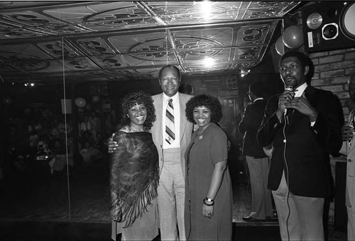 Tom Bradley posing with two unidentified women at a rally for his re-election, Los Angeles, 1983