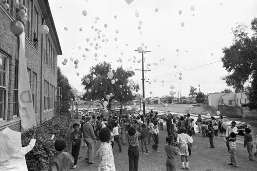 Ritter Elementary School children watching the release of balloons, Watts (Los Angeles, Calif.), 1983