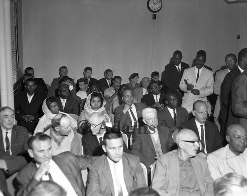 Malcolm X sitting with Delores Stokes in a court room, Los Angeles, 1963