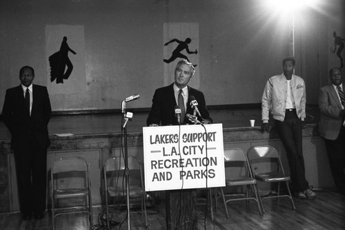 Jamaal Wilkes and Tom Bradley listening to a speaker at the Harvard Recreation Center, Los Angeles, 1983