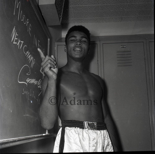 Cassius Clay pointing to a chalk board in anticipation of his fight with Archie Moore, Los Angeles, 1962