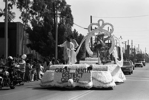 Young women waving from a float for the 9th District Queen during the South Central Los Angeles Easter Parade, Los Angeles, 1983