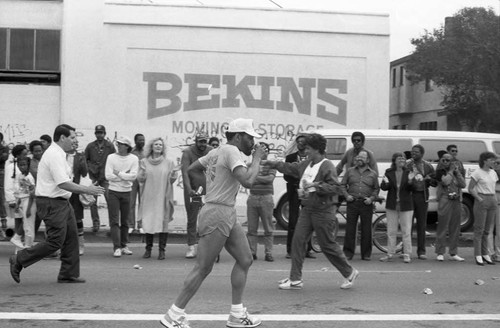 Runner sipping a drink during the first Los Angeles Marathon, Los Angeles, 1986