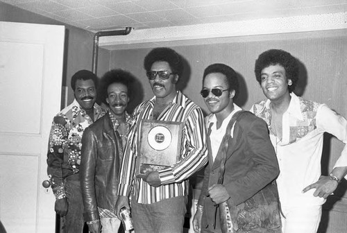 The Miracles posing with a plaque at KGFJ's Soul Search event, Los Angeles, 1975