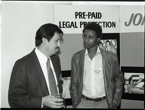 Association of Independent Printers event attendees talking near a display, Los Angeles, 1986