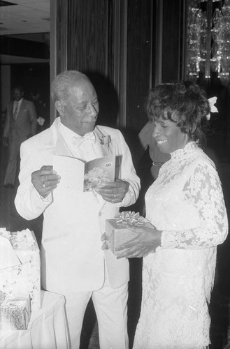 James and Odessa Bohana standing near gifts during their 50th wedding anniversary celebration, Los Angeles, 1984