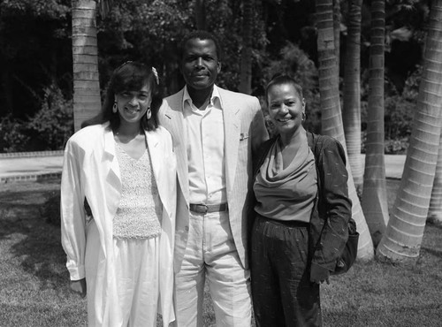 Sydney Poitier posing with two unidientified women, Los Angeles, 1986