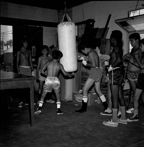 Boys lining up to hit a punching bag, Los Angeles, 1971