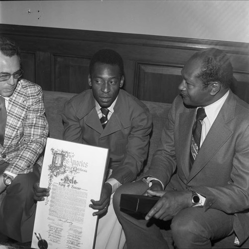 Pelé holding a commendation and speaking with Mayor Tom Bradley, Los Angeles, 1975