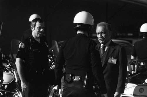 Jesse Brewer speaking with a motorcycle officer, Los Angeles, 1983