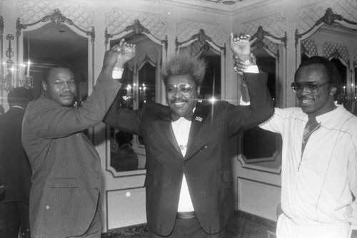 Don King, Larry Holmes, and Michael Dokes posing at press conference for the "Crown Affair" boxing event, Los Angeles, 1983