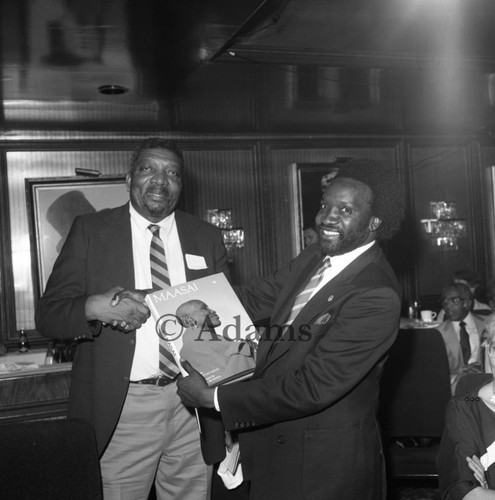 Two men with book, Los Angeles, 1984