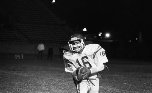 Crenshaw High School football player carrying the ball, Long Beach, California, 1982