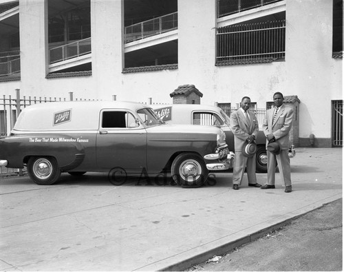 Men stand next to company vehicles, Los Angeles, 1954