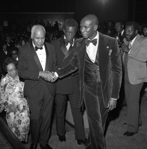 Louis Gossett, Jr. guides Roy Wilkins to the stage during the NAACP Image Awards,Los Angeles, 1978