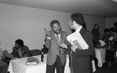 Amiri Baraka talking with a man at a UCLA conference on Black literature, Los Angeles, 1983