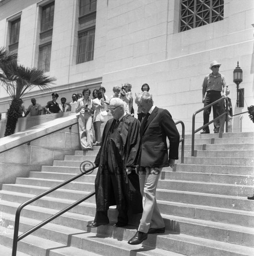 Earl Warren and Lloyd Bridges walking down the steps of City Hall at Tom Bradley's inauguration, Los Angeles, 1973