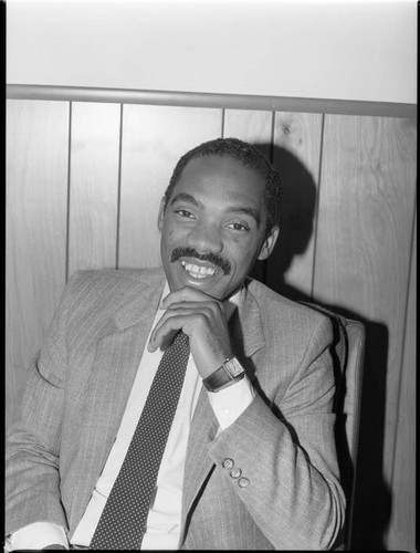 African American automobile dealer posing in his office, Los Angeles, 1983