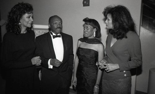 Willie Brown speaking with three unidentified woman at a formal event, Los Angeles, 1989