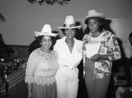 Guests posing together at the National Association of Media Women's western hoedown, Los Angeles, 1983