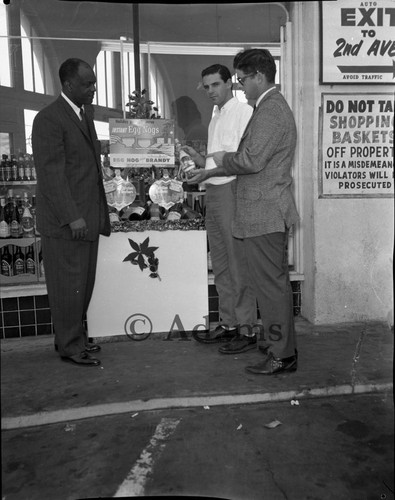 Three men standing at a store's holiday display, Los Angeles, ca. 1962