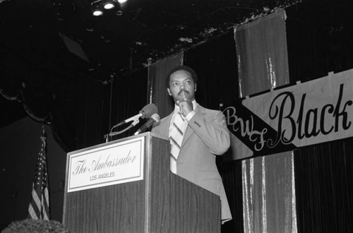 Jessie Jackson standing at a lectern during a Black Women's Forum event at the Ambassador Hotel, Los Angeles, 1984